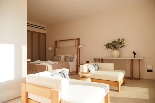 a living room with a bed and a couch and chairs at Luxury Stone Houses Corfu in Píthos