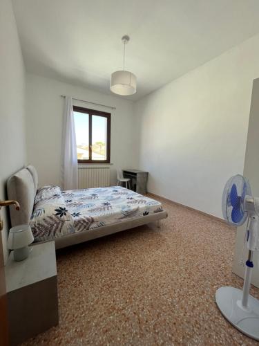 una camera con letto, finestra e ventilatore di Il Sogno a Senigallia