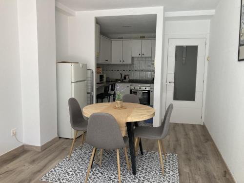 uma sala de jantar com uma mesa e cadeiras numa cozinha em La Lúnula by Twelve Apartments VUT3392AS em Gijón