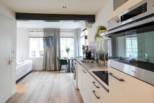 een keuken met een wastafel en een fornuis top oven bij Deluxe 20m2 Canal View in Delft