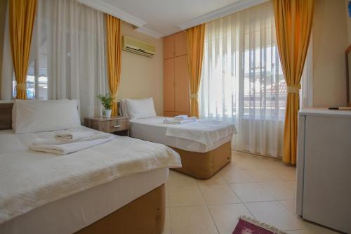 a hotel room with two beds and a window at Huzur Royal Hotel in Datca