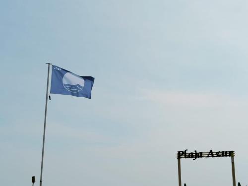 a flag of the chinese communist party flies next to two signs at Vila Plaja Azur in Eforie Nord