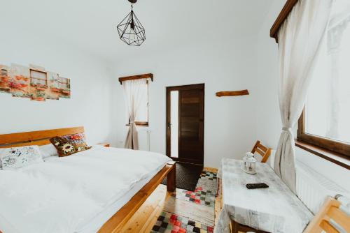 1 dormitorio con cama, mesa y ventana en Casa Florea Stanceni en Ciobotani