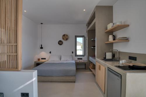 a small bedroom with a bed and a kitchen at Clementina Paros in Naousa