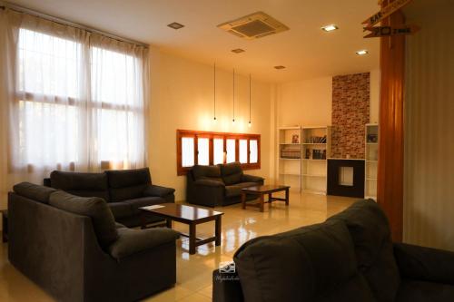 a living room with two couches and a table at Hospedium DLJ Hostal Ben Nassar in Arjona