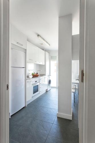 una cucina con armadietti bianchi e pavimento piastrellato di Habitur Experiences a Olite