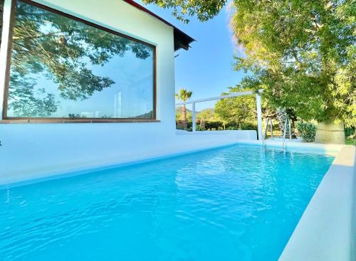 a swimming pool with blue water in front of a house at Villa Only Adults 2 Pax · Piscina Privada · A/C · WIFI · BBQ in Blanes