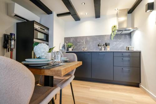 a kitchen with a wooden table and a counter at Luxury City Center Studio in Delft