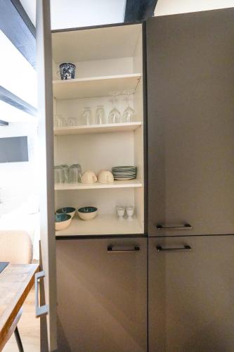a cabinet with plates and bowls in it at Luxury City Center Studio in Delft