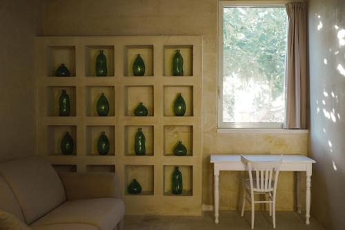 a room with a table and a window with green vases at Masseria Paralupi in Lecce