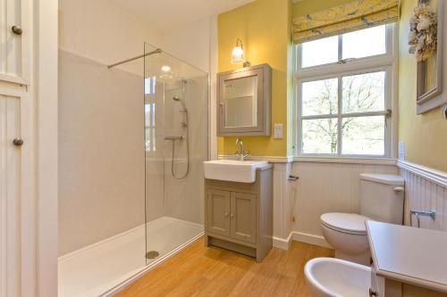 a bathroom with a toilet and a sink and a shower at Charcoal House in Coniston