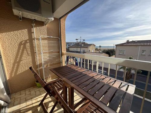 - un balcon avec un banc en bois dans l'établissement Studio à 50m de la plage, à Saint Pierre La Mer