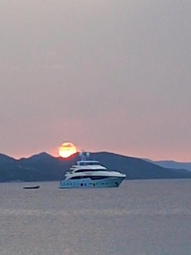 un yacht dans l'eau avec le coucher du soleil en arrière-plan dans l'établissement Casa Maja, à Koločep