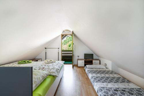 1 dormitorio en el ático con 2 camas y espejo en Ladybug House With Whirlpool en Fokovci