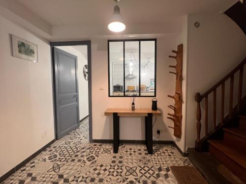 une petite table dans un couloir avec une fenêtre dans l'établissement O Quinze du Salat, à Mazères