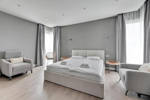 a bedroom with a bed and a couch and a chair at GRANO HOTEL Solmarina in Wiślinka