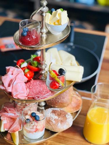 a three tiered tray of cheese and other appetizers at Ferienwohnung Honeymoon Deluxe Wellness mit Sauna auf Schloss Falkenhorst in Kleinblittersdorf