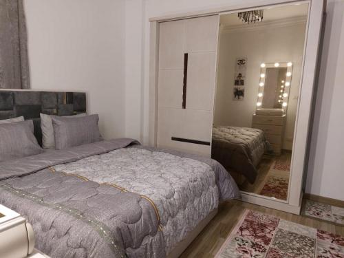 a bedroom with a large bed and a mirror at مدينتي in Madinaty