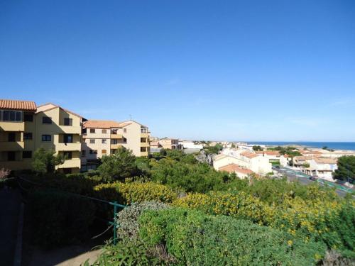 vistas a una ciudad con edificios y al océano en T2 avec une vue panoramique sur la mer, en Saint Pierre La Mer