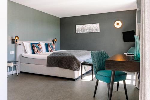 1 dormitorio con cama, escritorio y silla en B&B Brasserie Villare en Wijlre