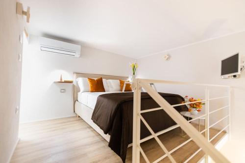 una camera bianca con letto e TV di Il Melograno Suite Apartment a Martina Franca