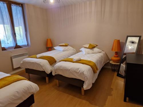 Pokój z 3 łóżkami z żółtą pościelą i oknem w obiekcie Gîtes du Château de Crespy 