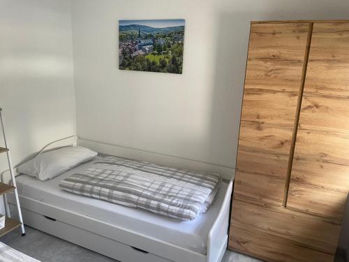 a bedroom with a bed and a wooden closet at Ferienwohnung an der Linde in Bischofsheim an der Rhön