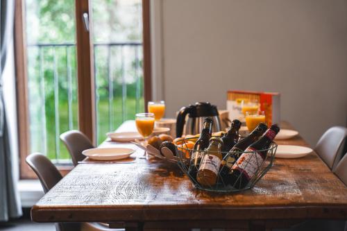 a wooden table with a basket of wine bottles on it at Vakantiewoning & Fietslogies V E L O, Tussen Hasselt en Maastricht in Bilzen