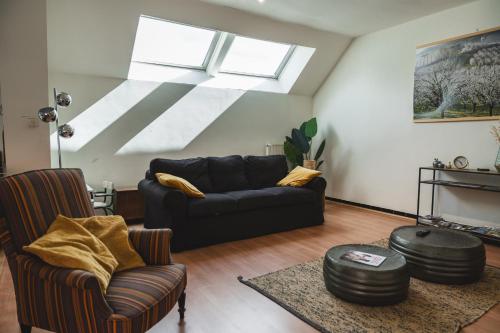 a living room with a couch and chairs and a skylight at Vakantiewoning & Fietslogies V E L O, Tussen Hasselt en Maastricht in Bilzen