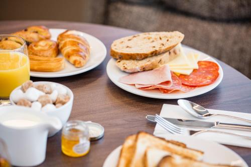 a table with two plates of breakfast food on it at AC Hotel by Marriott Birmingham in Birmingham