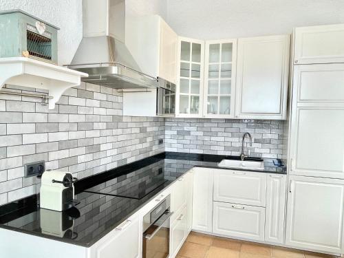 a white kitchen with white cabinets and a sink at Villa Only Adults 2 Pax · Piscina Privada · A/C · WIFI · BBQ in Blanes