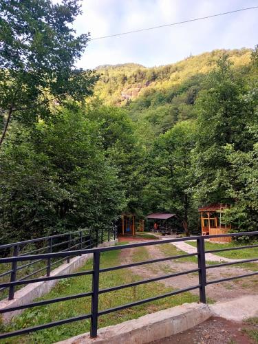 a fence in front of a mountain with a cabin at Happy days house in Shuakhevi