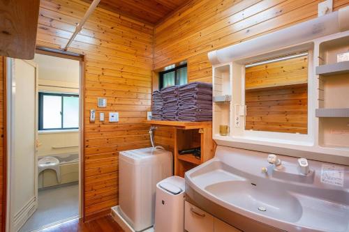 奄美市にある大人数で泊まれる宿一棟貸しkise-㐂瀬-のバスルーム(白い洗面台、トイレ付)