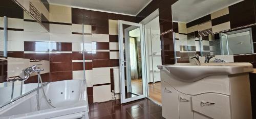 a bathroom with a sink and a tub and a toilet at Pensiunea Four Seasons in Curtea de Argeş