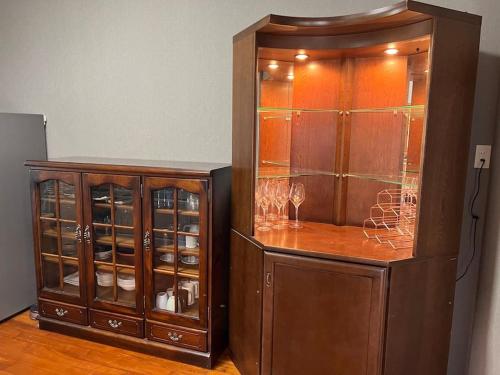 a large wooden cabinet with glasses in it at 大人数で泊まれる宿一棟貸しkise-㐂瀬- in Amami