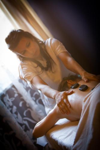 a woman is laying on a bed with her shirt on at Hotel Comfort Erica Dolomiti Val d'Adige in Salorno sulla Strada del Vino