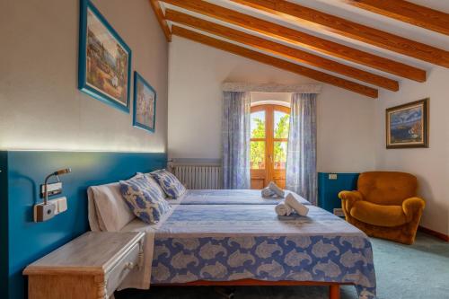 1 dormitorio con 1 cama, 1 silla y 1 ventana en Villa Marjals, en Muro