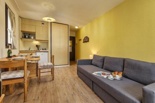 un salon avec un canapé et une table et une cuisine dans l'établissement Chamonix Sud - Bâtiment F 400 - Happy Rentals, à Chamonix-Mont-Blanc