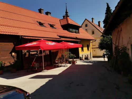 a group of red umbrellas in front of a building at PENZIJON URBANC in Lovrenc na Pohorju
