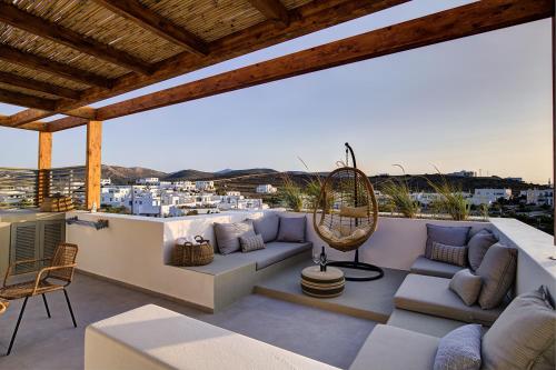a patio with a couch and chairs on a balcony at Clementina Paros in Naousa
