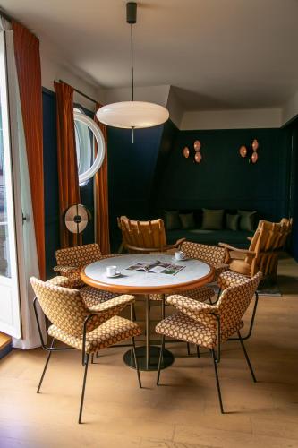 a dining room with a table and chairs at Hôtel Le Ballu in Paris
