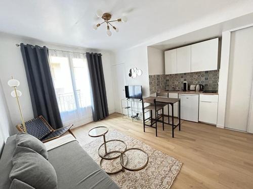 een woonkamer met een bank en een tafel en een keuken bij Paris cosy studio near Beaugrenelle and Eiffel Tower in Parijs