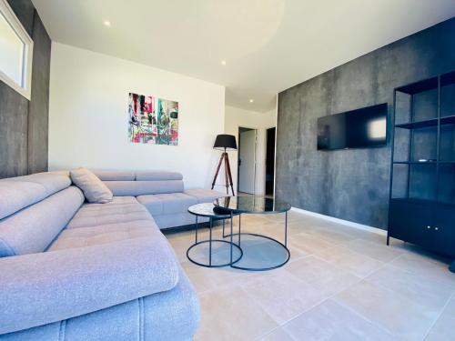 a living room with a couch and a glass table at Bella Vista Hôtel, Suites & Maisons in Porticcio