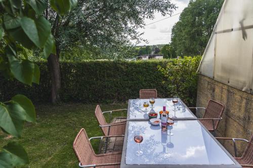 a table with wine glasses on it in a yard at Vakantiewoning & Fietslogies V E L O, Tussen Hasselt en Maastricht in Bilzen