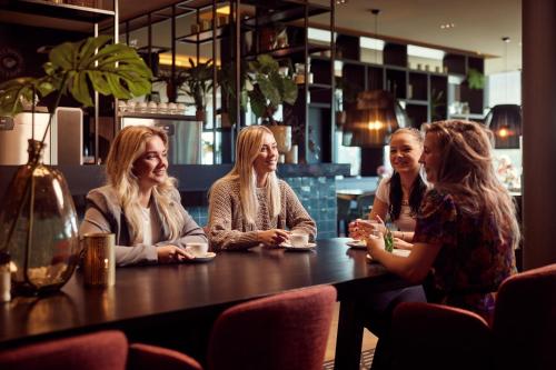 a group of women sitting at a table in a restaurant at Van der Valk hotel Veenendaal in Veenendaal