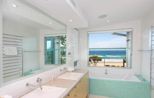 a bathroom with two sinks and a tub and a window at 38 Seaview Terrace, Sunshine Beach in Noosa Heads