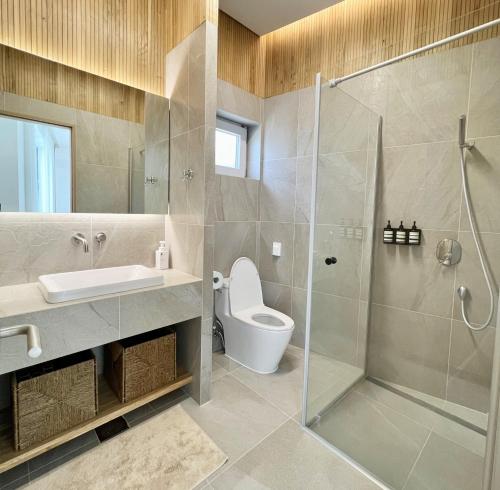 uma casa de banho com um chuveiro, um WC e um lavatório. em Pohang Poolvilla Dearmood em Pohang