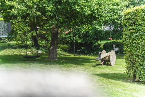 a garden with a fire hydrant in the grass at Vakantiewoning & Fietslogies V E L O, Tussen Hasselt en Maastricht in Bilzen
