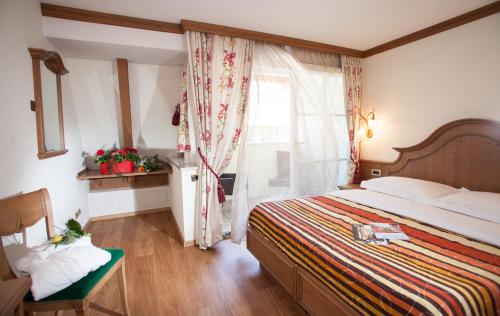 a bedroom with a large bed and a window at Hotel Comfort Erica Dolomiti Val d'Adige in Salorno sulla Strada del Vino