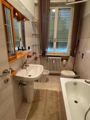 a bathroom with a sink and a toilet and a tub at Accogliente Loft ben servito in Novara